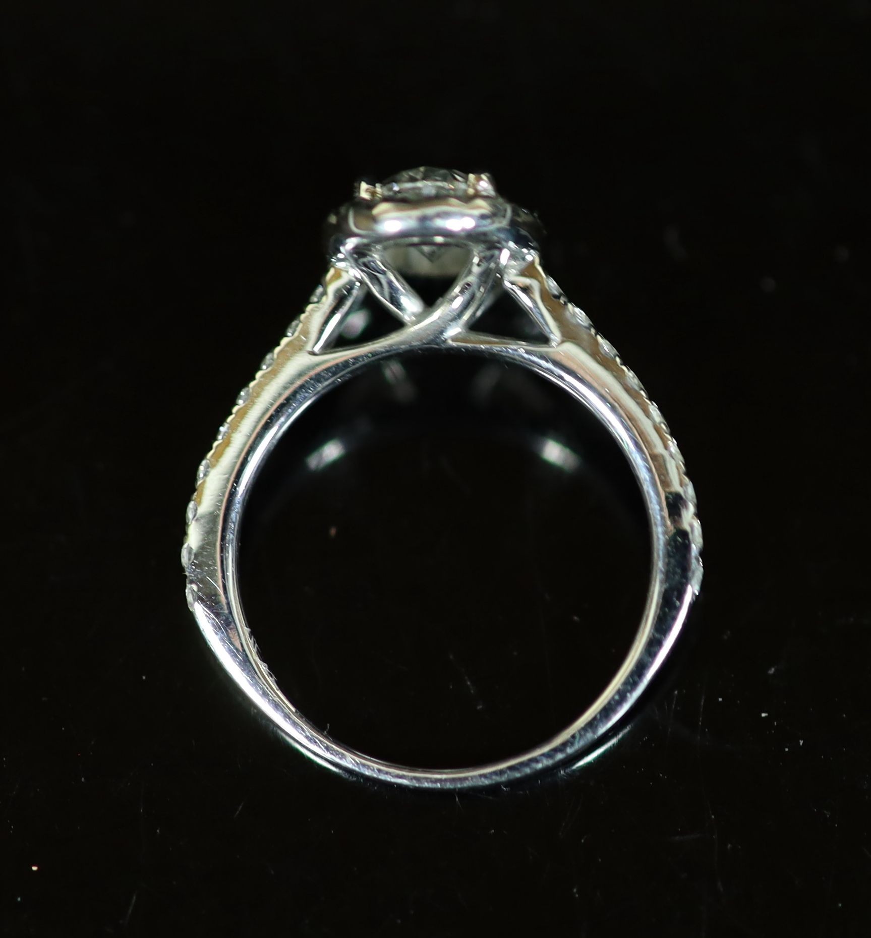 A Rox platinum and oval cut single stone diamond ring, with diamond set border and diamond set shoulders